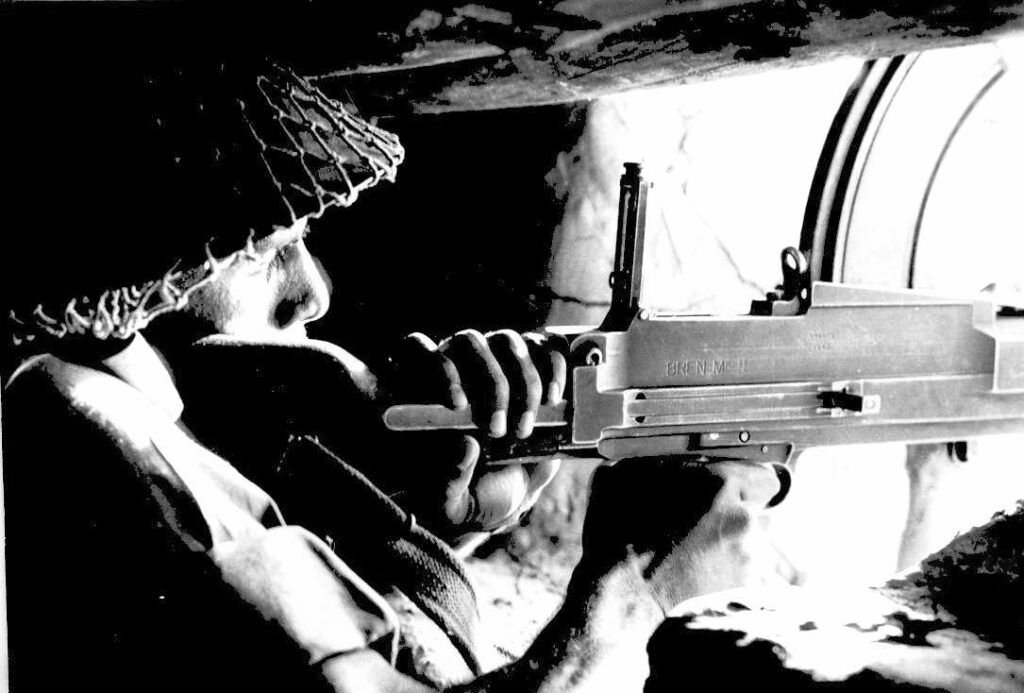 BSF constable inside a bunker at the India-Pakistan border with a light machine gun